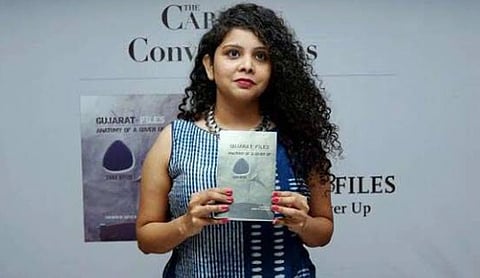 Image of Journalist Rana Ayyub holding her book Gujarat Files: Anatomy of a cover up.