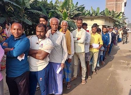 In the image a cue is shown with papers in their hands from bihar waiting for their turn to give vote