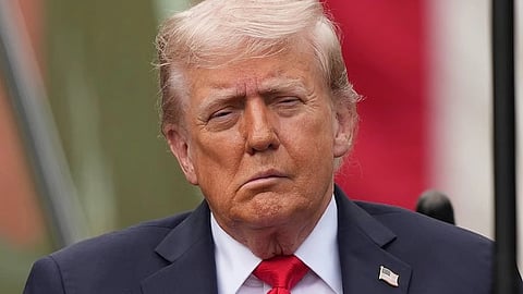 Close up shot of Donald Trump in his classic dark blue suit and red tie. he is wearing a tiny badge of the national flag of United States of America.
