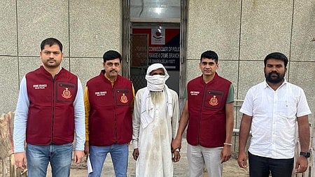 Delhi Police officers with the apprehended interstate gang leader accused of organising multiple bank burglaries posing infront of the police station.
