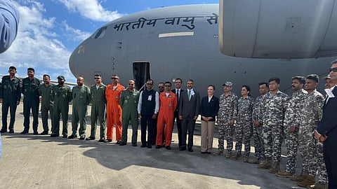 Human aids posing for a photo standing infront of a Air India aircraft which has the disaster relief goods. 