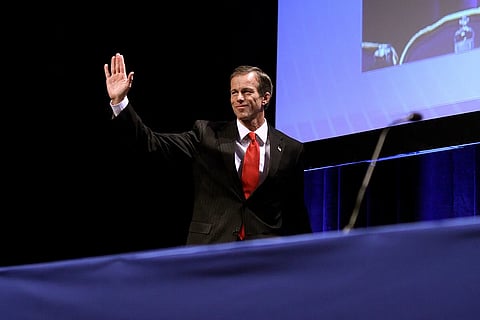 US Senate Majority Leader John Thune waving from a stage in 2011.