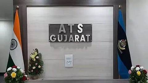 'ATS Gujarat' written on the wall of a Gujarat Police offices, with Indian and police flags on either side.