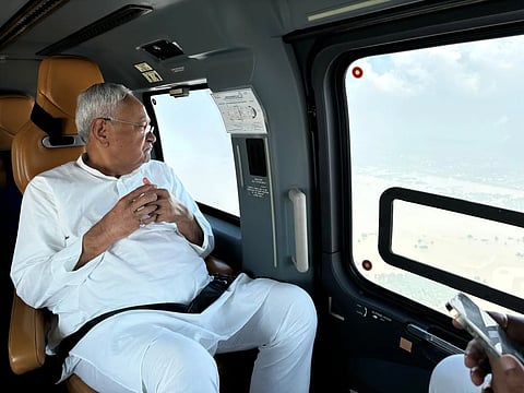 Nitish Kumar looking out of a helicopter window.