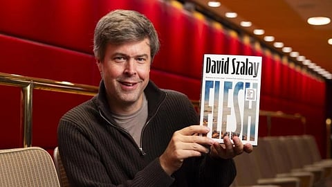 In the image author David Szalay is showing of his book Flesh 