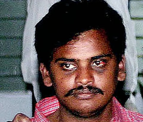 Closeup image of Surinder Koli who was a convict in the Nithari killings of 2005-2006. The image is a low resolution portrait of Koli wearing a pink check shirt