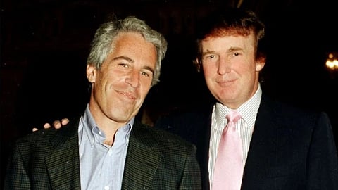 Jaffery Epstein, dressed in a plaid jacket and US President Donald Trump wearing a dark suit with a pink tie standing side by side, smiling at the camera.  The setting is warmly lit.