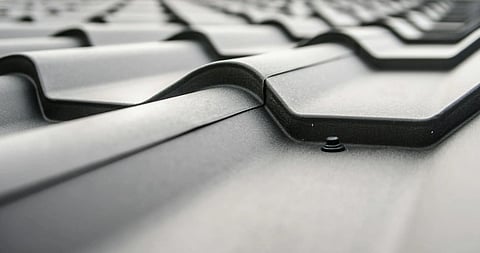 Close-up of a steel roof with corrugated panels in perspective, emphasizing smooth, wave-like curves and a sleek, modern industrial design.
