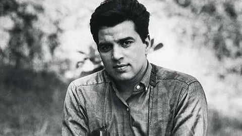 In the image Dharmendra is shown posing at the camera the image is black and white