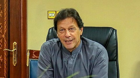 Imran Khan is sitting in a chair, facing others who are smiling and seated on the right. The atmosphere appears formal yet relaxed.