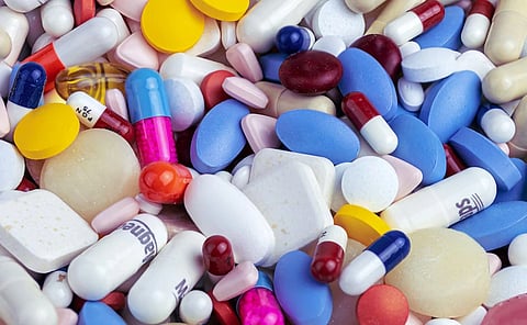 Close up of many different kinds of pills in a pile.