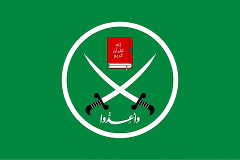 Flag of the Muslim Brotherhood. A green background, with a white circle on it. Inside the circe are two crossed swords, with a red book above, and some arabic text below.