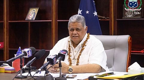 In the image Prime minister of Samoa is shown in a conference he is wearing a white shirt with a garland necklace