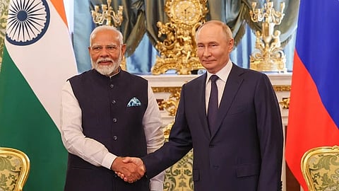 In the image Russia President Vladimir Putin and India Prime Minister Narendra Modi is shown shaking hands Modi is wearing an Indian suit and Putin is wearing a formal western suit. Behind them are India Russia Flags