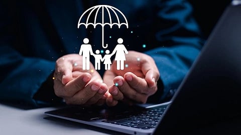 Hands cradle a graphic of a family under an umbrella above a laptop, symbolizing protection and security in a digital context.
