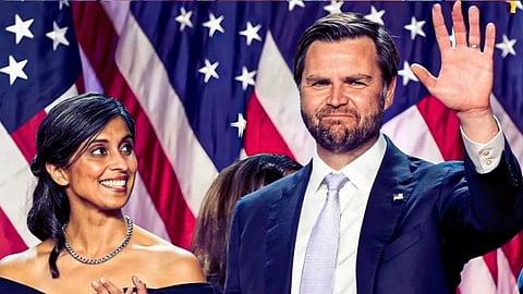 U.S. Vice President J.D. Vance and his wife Usha Vance formally dressed, with the man waving, against a backdrop of U.S. flags. Usha is looking at J.D. Vance.