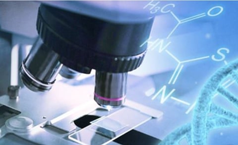 Close-up of a microscope examining a glass slide, overlaid with blue-toned chemical formulas and a DNA strand, conveying scientific exploration and research.