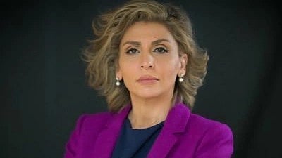 Pantea Modiri looking at the camera wearing coat and shirt proudly the background is black