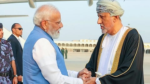 PM Modi is seen shaking hands with Oman's Deputy Prime Minister for Defence Affairs Sayyid Shihab bin tariq Al Said. The background is Oman's airport.