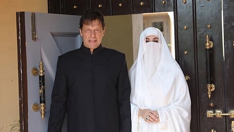 In the image Imran Khan is shown wearing black kurta and beside him is his wife Bushra bibi wearing white burqa