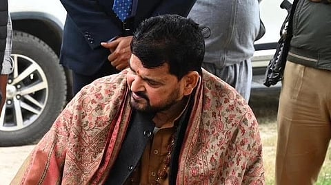 In the image Brij Bhushan is shown looking at someone on the side behind him are men standing