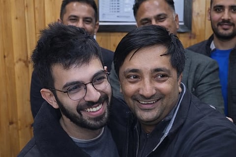 Two men hugging each other. One is the doctor of IGMC Hospital and the other is patient behind them are men standing everyone is with a smile in face