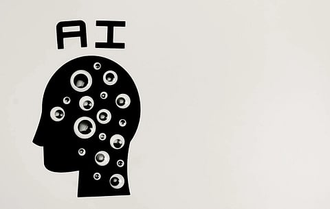 Silhouette of a head filled with various-sized googly eyes, against a white background. "AI" is written above, suggesting artificial intelligence.