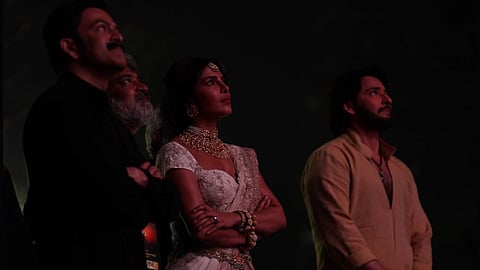Director SS Rajamouli with actor Mahesh Babu, Pritviraj Sukumaram and actress Priyanka Chopra Jonas at the Hyderabad premiere of Varanasi against a dim backdrop. 
