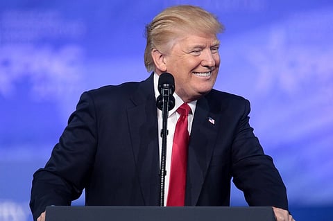 Image of president Trump giving speech in front of a podium with a blue background. He is  speaking at the 2017 Conservative Political Action Conference (CPAC) in National Harbor, Maryland.