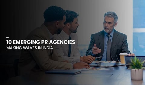 Three men in business attire are engaged in a serious meeting. A caption reads: "10 Emerging PR Agencies Making Waves in India." Bright, professional setting.