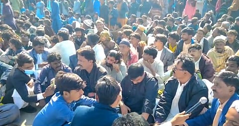 The image depicts a large group of people protesting against the Pakistan government over the killing of Kailash Kohli.