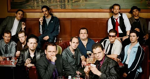 Image of various people sitting and posing with tables with alcohol on them. The image is of a cover photograph of the infamous PayPal mafia.