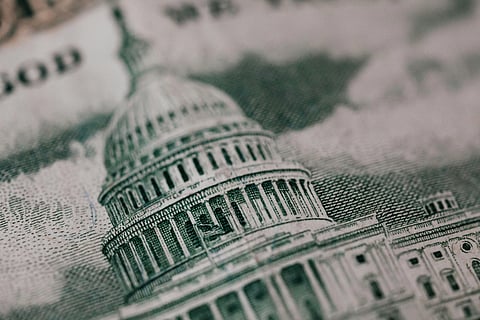 Close-up of a dollar bill showing the intricate design of the U.S. Capitol building. The image is detailed, emphasizing the architectural elements.