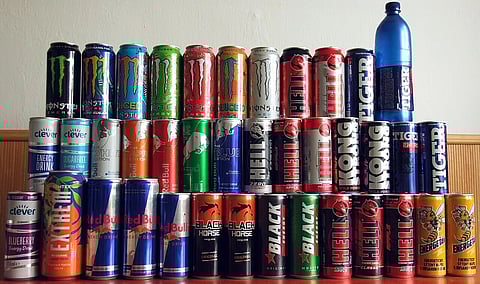  Energy drinks of various brands stacked on top of each other.
