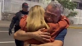 release the political prisoners of venezuela a man hugging the women and a officer behind them