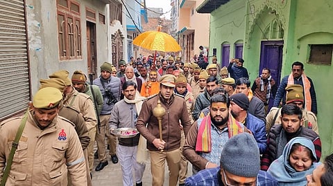 CO Anuj Chaudhary, along with other police officers and members of a religious outfit, walking along the streets of Sambhal with a gadha.