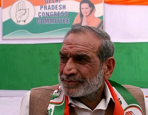 Sajjan Kumar looking to his left, behind a poster of Delhi Pradesh Congress Committee