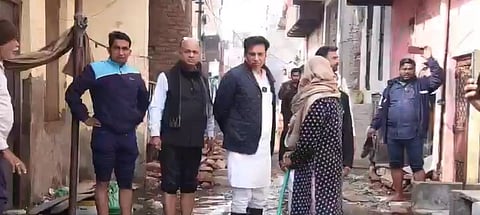 Congress Leader Devender Yadav inspecting the Sharma Enclave area along with other officials and local residents. The area is dirty, sewage water is more than ankle length, some of the people are wearing gumboots, while some are not wearing any gumboots.