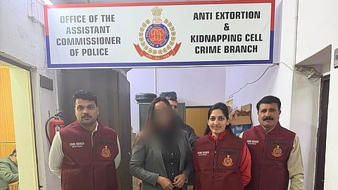 Four people stand under a sign for the Anti Extortion & Kidnapping Cell Crime Branch. They wear maroon vests, looking formal and professional.