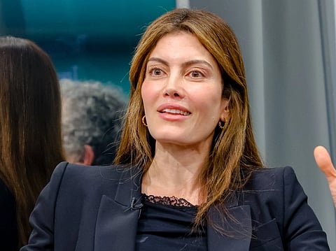 Image of Laila Cunningham with light brown hair in a black blazer speaks animatedly. She appears engaged and expressive, with a blurred background adding depth.