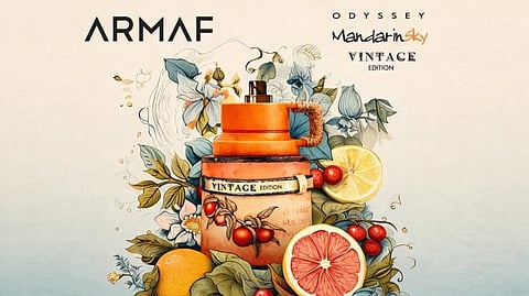 Perfume bottle labeled "Vintage Edition" surrounded by vibrant florals and fruits like oranges and grapefruit. The mood is fresh and nostalgic.