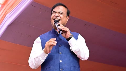 Himanta Biswa Sarma on stage, smiling while speaking into a mic