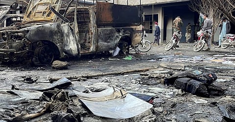 burned vehicles and debris lie on the road in the aftermath of attacks by the BLA in Balochistan.