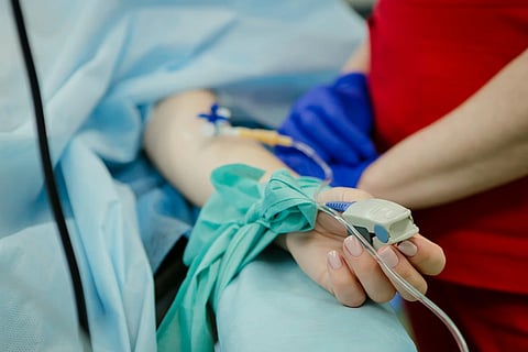 A patient's hand recieving fluids by a nurse