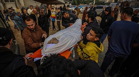 People carry a body wrapped in cloth on stretcher in Gaza after the ceasefire.