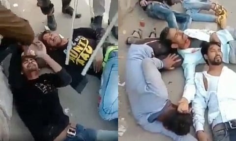 Two screenshots of a video from the 2020 Delhi riots shows several men lying bloody and beaten on the ground surrounded by police in riot gear.