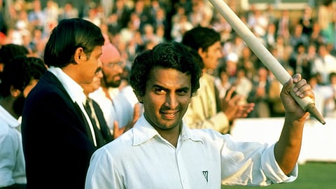 In the image sunil gavaskar is shown raising a stumb smiling at the camera
