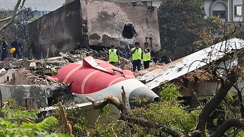 A crashed plane lies among damaged buildings and trees. Emergency personnel in high-visibility vests assess the scene, conveying urgency and seriousness.