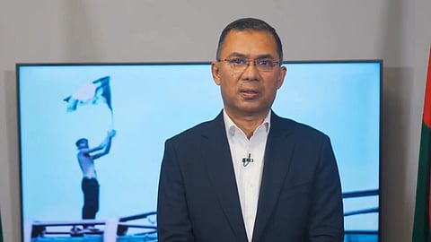 Tarique Rahman wearing a suit and standing straight