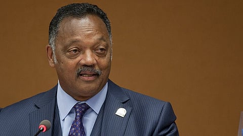 In the image Jesse Jackson is shown wearing a format attire adressing the audience